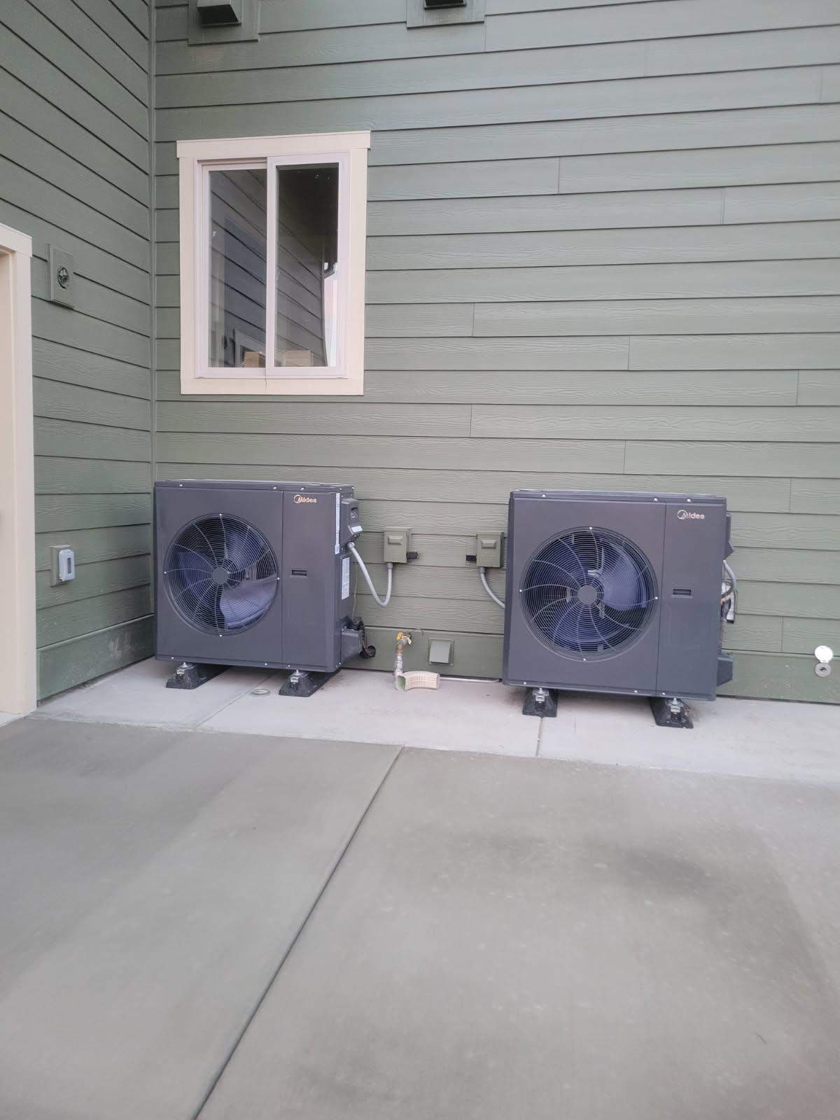 Dual Midea heat pump outdoor units installed side by side on a Central Oregon home