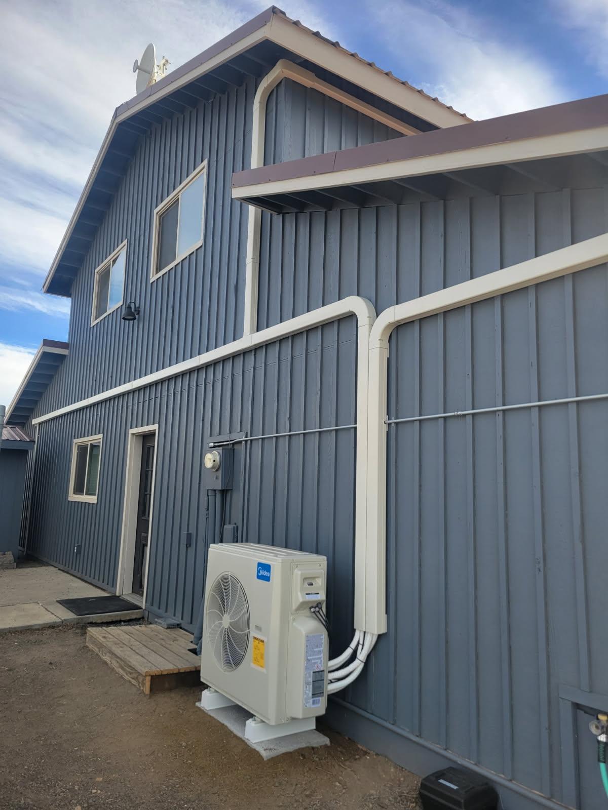 Ductless mini-split heat pump installed on a barn-style home exterior in Redmond, Oregon