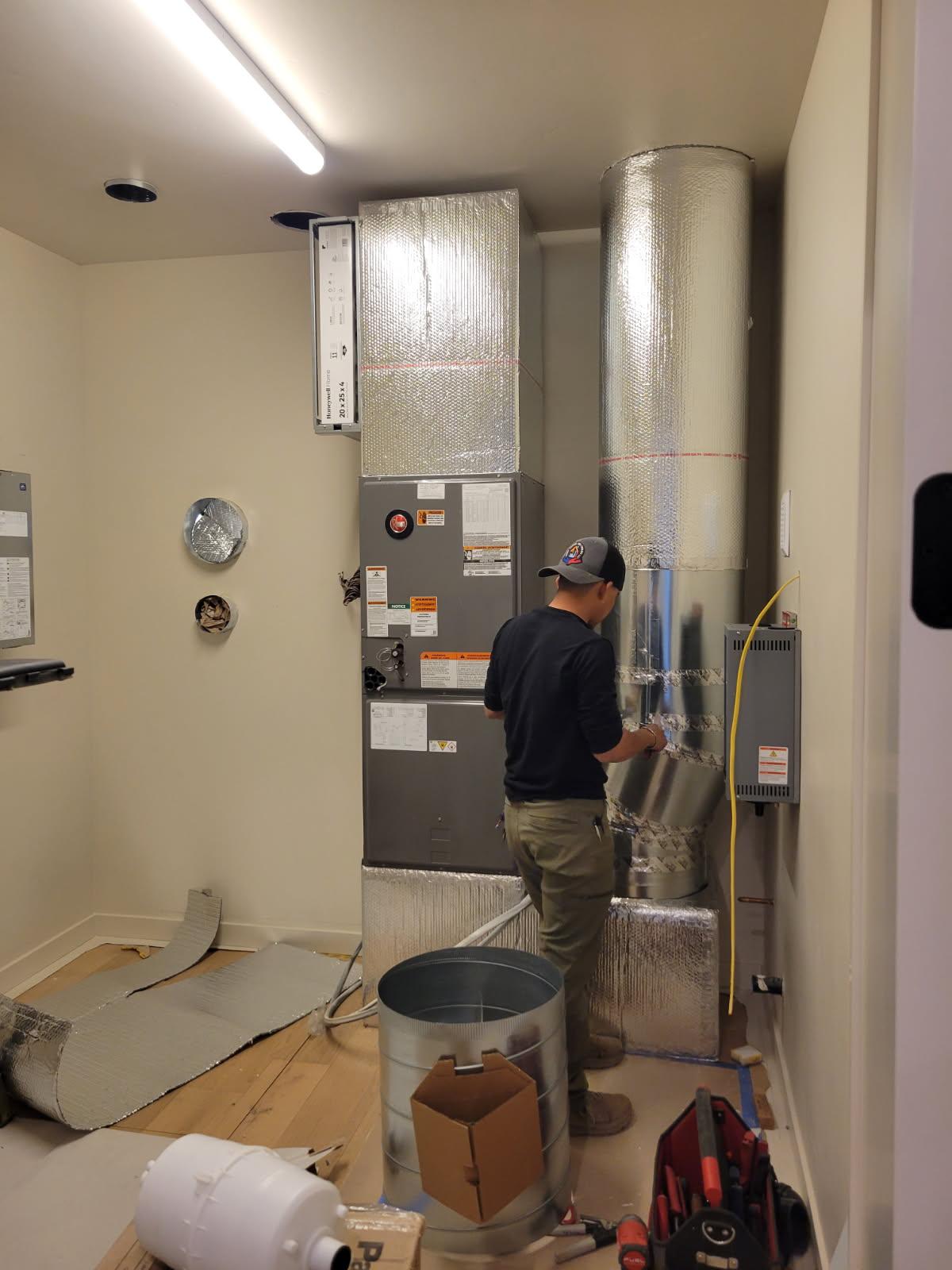 Terra technician installing an indoor HVAC air handler and insulated ductwork in Bend, Oregon